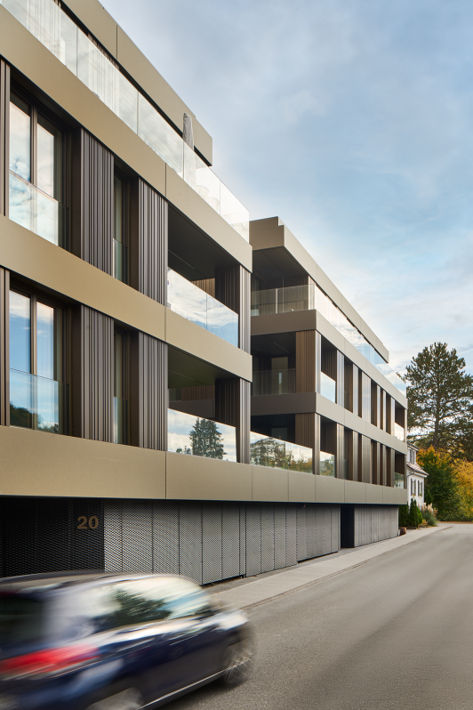 Moderne Wohnanlage in Nagold mit Fassade aus vertikalen Metalllamellen und großzügigen Balkonen entlang der Straße. geplant und umgesetzt von arc+ Freudenstadt