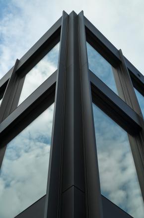 Die klar gegliederte Metall-Glas-Fassade des HF Mixing Neubaus steht für Präzision und technologische Kompetenz – entworfen und realisiert von arcplus