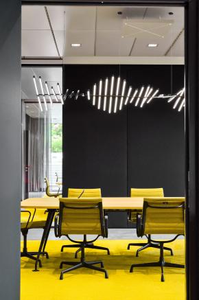 Konferenzraum im HF Mixing Verwaltungsneubau mit markanter Lichtinstallation, klarer Materialität und farblicher Akzentuierung – geplant und realisiert von arcplus.
