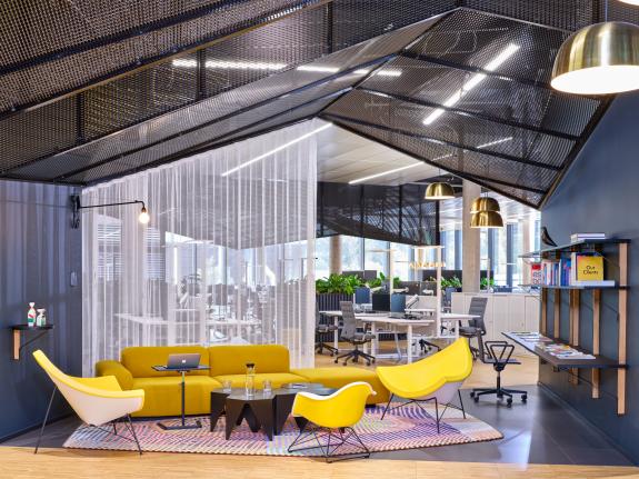 Lounge- und Kommunikationsbereich im HF Mixing Neubau mit offenen Arbeitsplätzen, flexibler Möblierung und transparenter Raumstruktur – geplant und umgesetzt von arcplus.