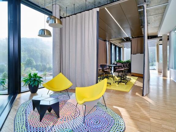 Flexible Besprechungs- und Projektbereiche mit mobilen Akustikvorhängen, offenen Kommunikationszonen, großzügigem Tageslichteinfall und Blick in die Landschaft im Verwaltungsneubau der HF Mixing Group am Unternehmensstandort in Freudenberg (Nordrhein-Westfalen). Das flexible Raumkonzept unterstützt agile Zusammenarbeit und schafft eine moderne Arbeitswelt für einen weltweit führenden Hersteller von Mischanlagen und Prozesslösungen für die Reifenindustrie, die technische Gummiwarenindustrie sowie Spezialanwendungen der Elastomerverarbeitung. Bauherr: HF Mixing Group. Geplant und umgesetzt von arc+ GmbH Freudenstadt.