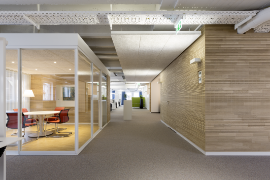 Hochwertig gestalteter Flurbereich mit verglastem Besprechungsraum, Holzoberflächen und offener Büroarchitektur im Büro am Vorstadtplatz für Häfele, internationaler Hersteller von Möbel- und Baubeschlägen, Schließsystemen und Beleuchtung, in Nagold. Bauherr: Häfele SE & Co KG. Geplant und umgesetzt von arc+ GmbH Freudenstadt.
