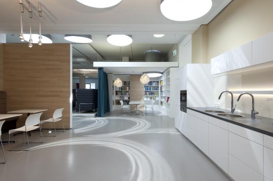 Sanierte Bürofläche bei Hansgrohe in Schiltach mit offener Kommunikationszone, Teeküche und integrierter Bibliothek – geplant von arcplus aus Freudenstadt