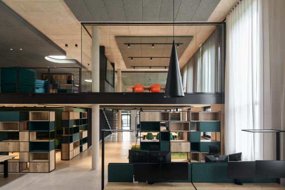 Offene Bürolandschaft mit Galerie, flexiblen Arbeitsplätzen, Besprechungsbereichen und Kommunikationszonen im Logistik- und Verwaltungsgebäude der SHW Logistik und Vertrieb GmbH, Hersteller von Schmiedeprodukten, Handwerkzeugen sowie Lösungen für Garten-, Forst-, Landwirtschafts- und Kommunaltechnik, in Freudenstadt. Bauherr: SHW Logistik und Vertrieb GmbH. Geplant und umgesetzt von arc+ GmbH Freudenstadt.